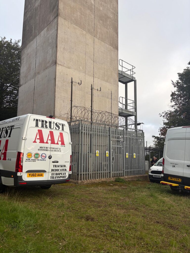 Secured telecoms mast tower with security cage, accessed by AAA Vans same-day courier fleet services